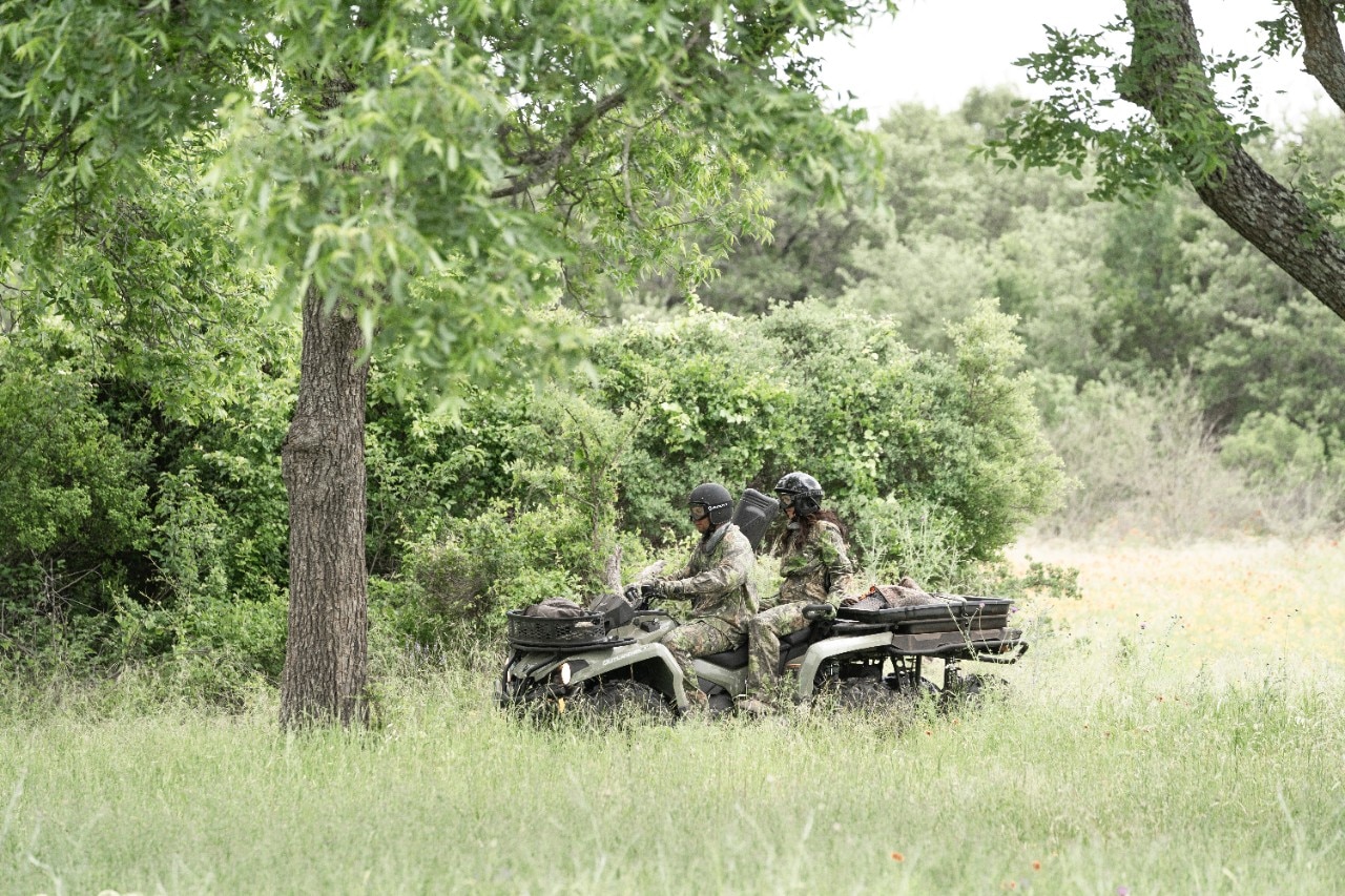 Dos cazadores conduciendo un ATV Can-Am Outlander MAX 6x6 DPS con asientos para 2 personas