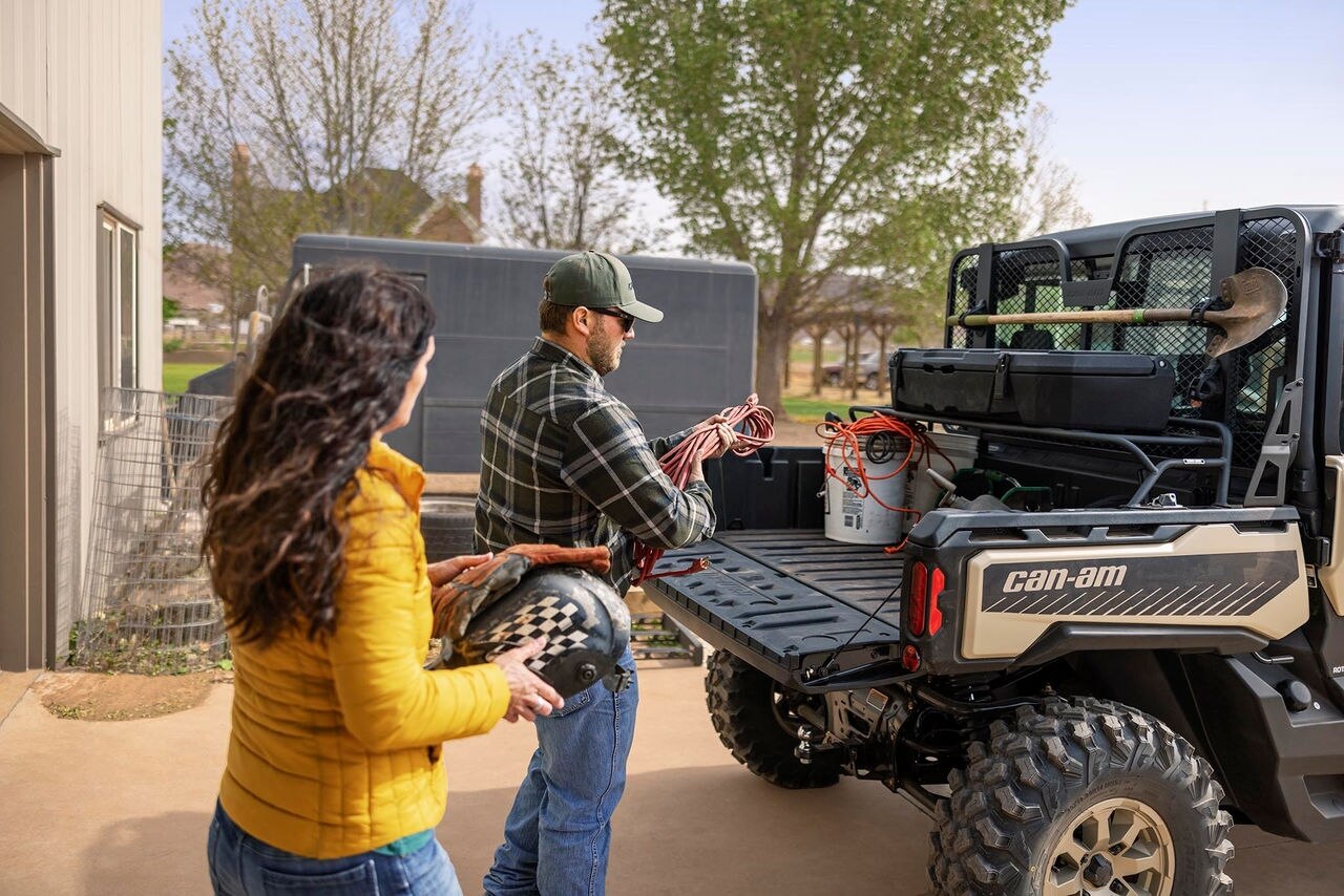 Man and woman load cargo on their Can-Am Defender