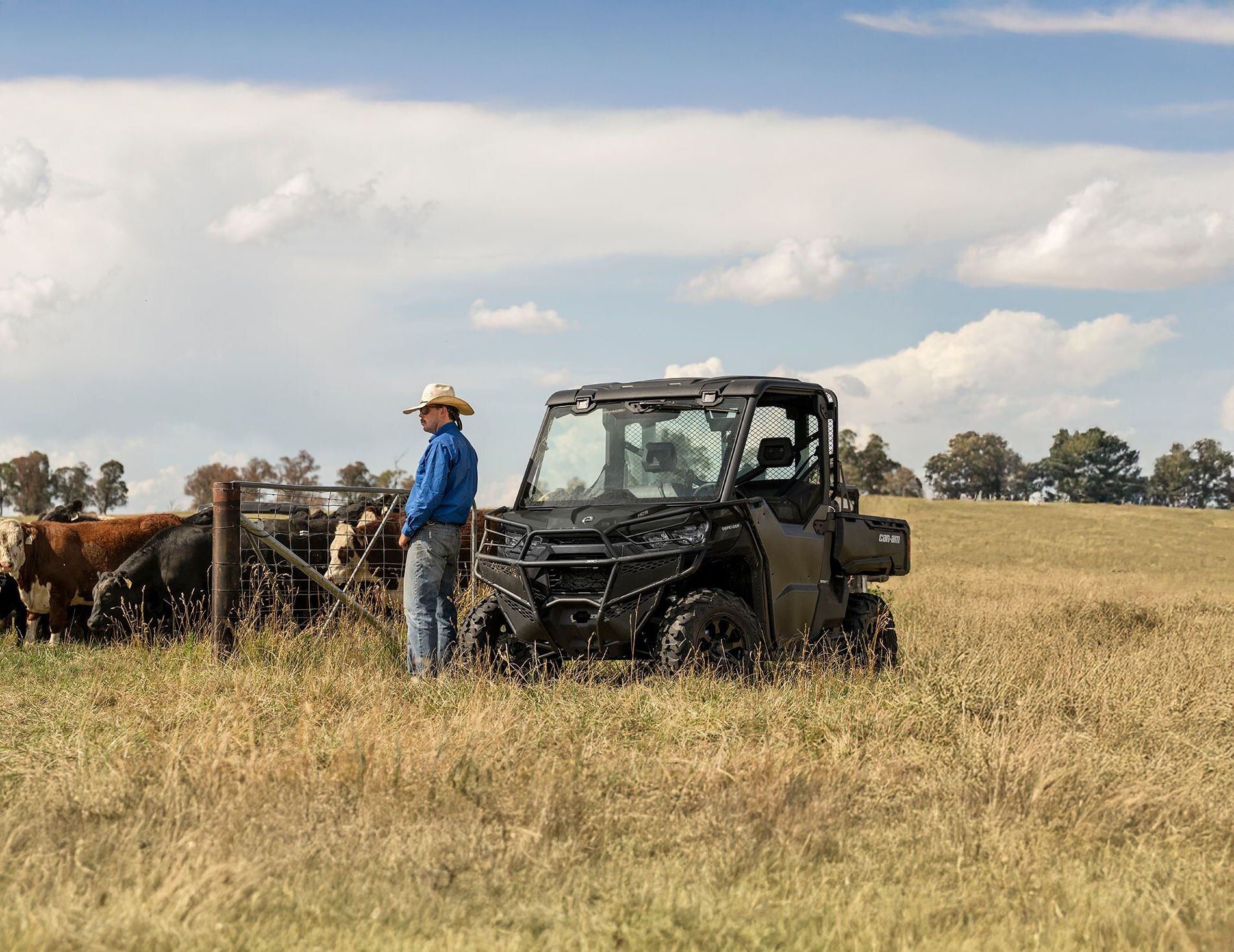 Un granjero descansando junto a su Can-Am Defender y unas vacas