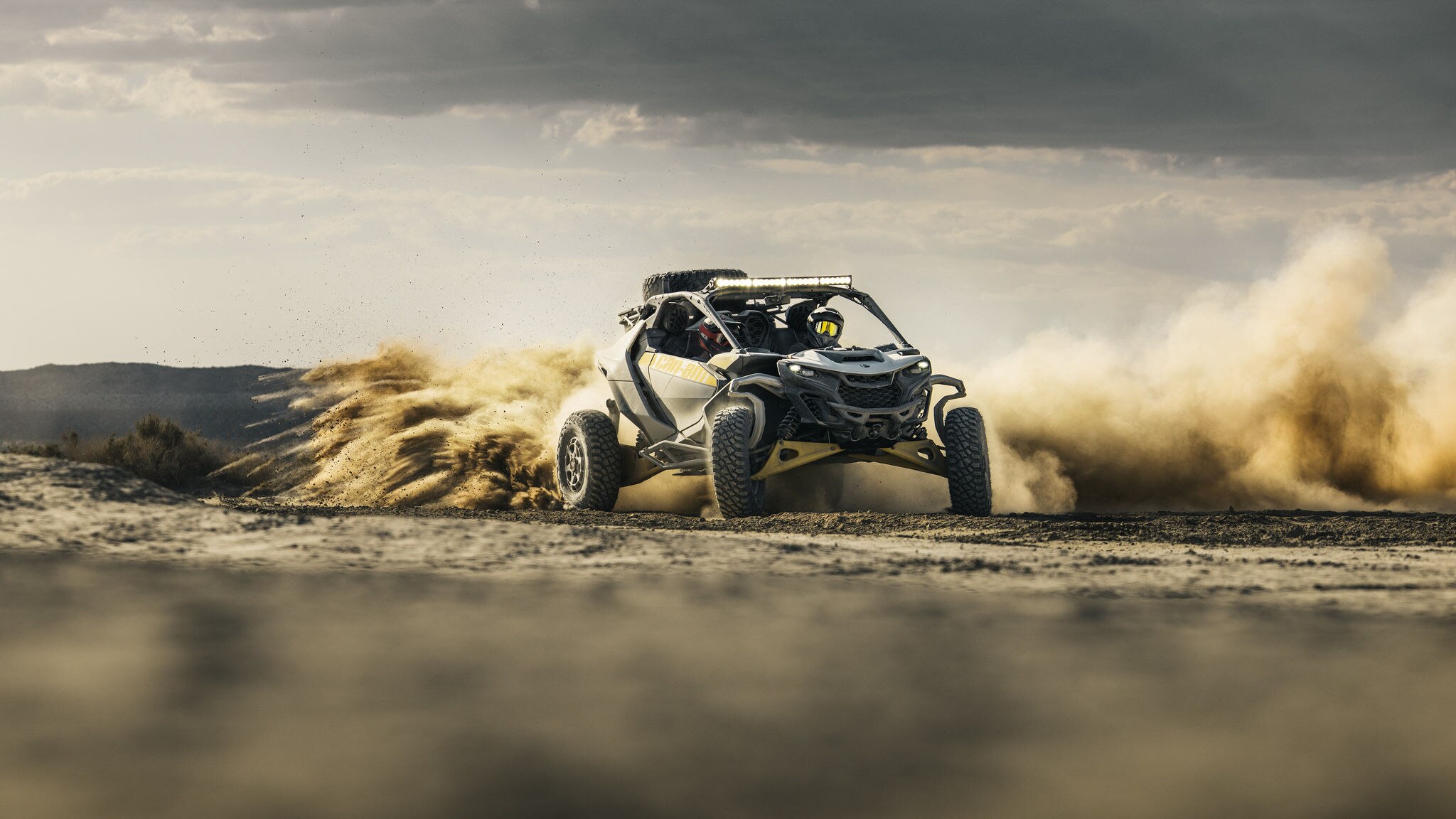Een Can-Am Maverick R die snel in de woestijn rijdt