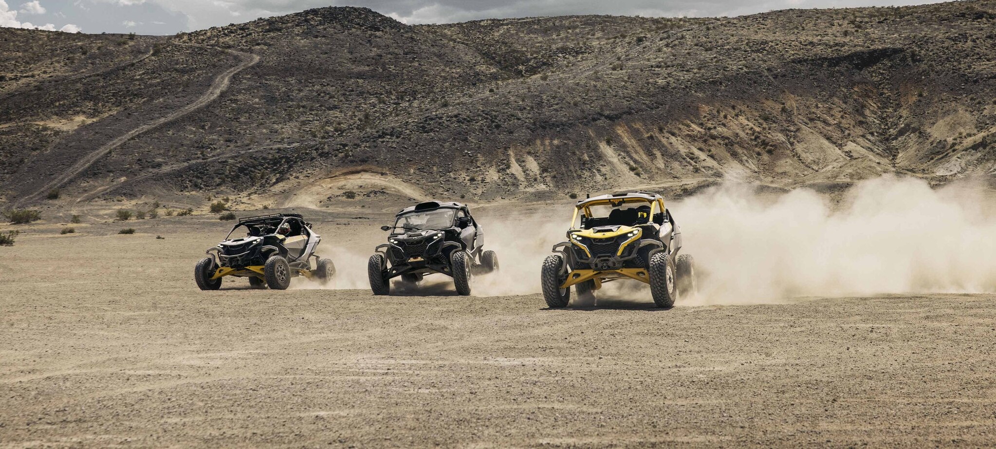 Tres vehículos Can-Am Maverick R SxS corriendo por el desierto