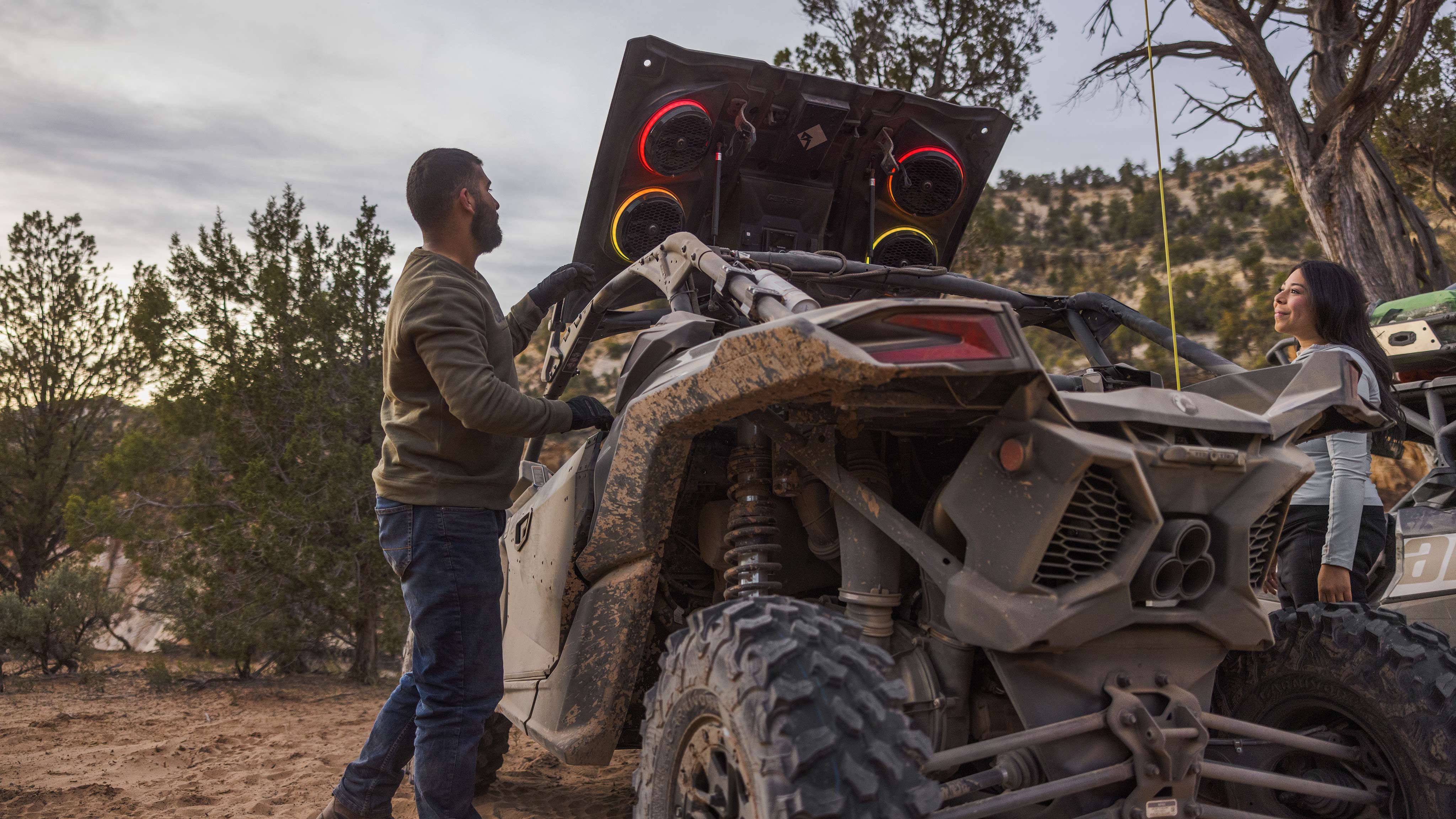 A rear view of a Mineral Grey and Desert Tan Can-Am Maverick X3 RC 72 Turbo RR with the audio roof and flip kit