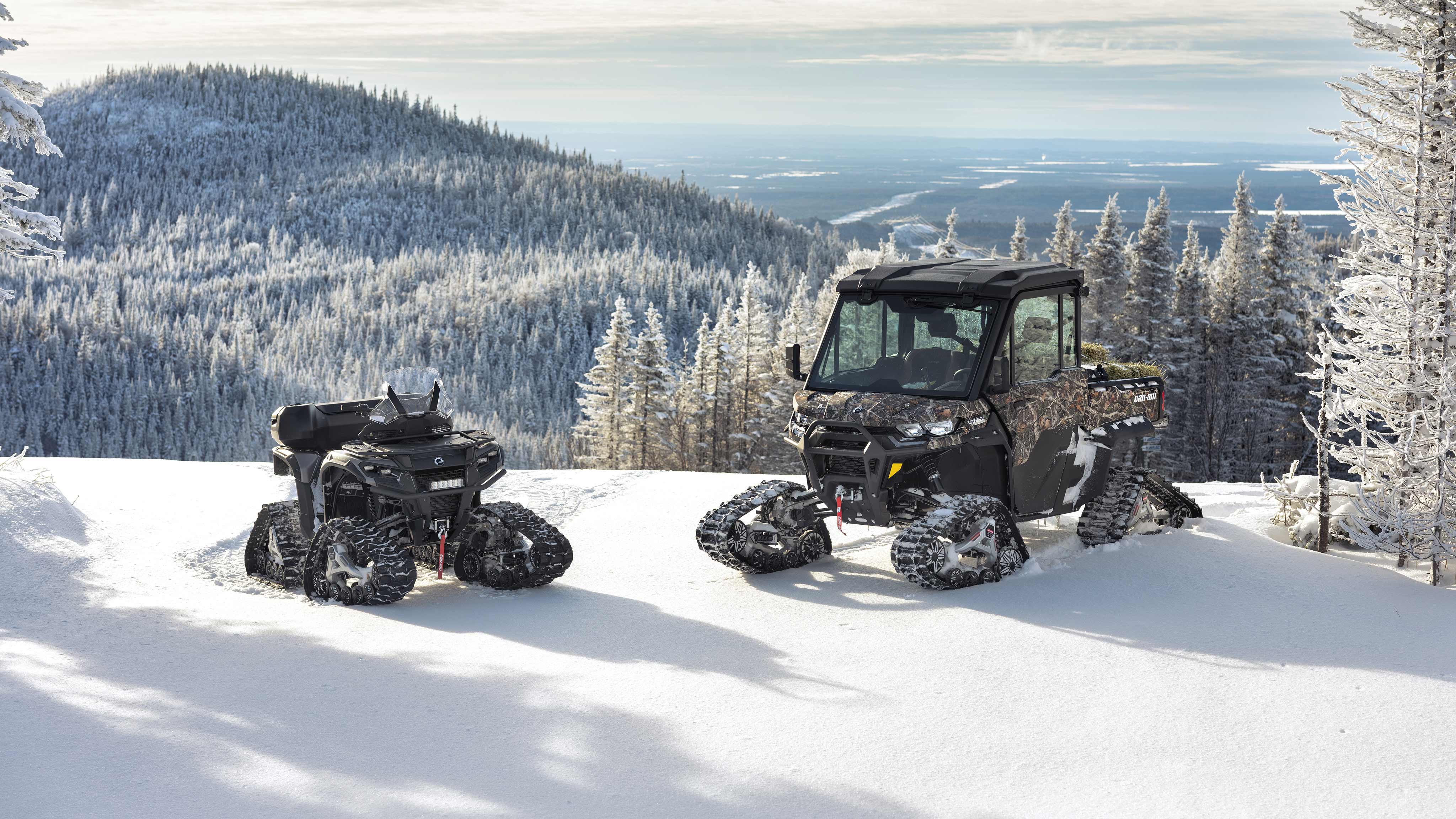 A Can-Am ATV and SxS with tracks on a snow-covered mountain
