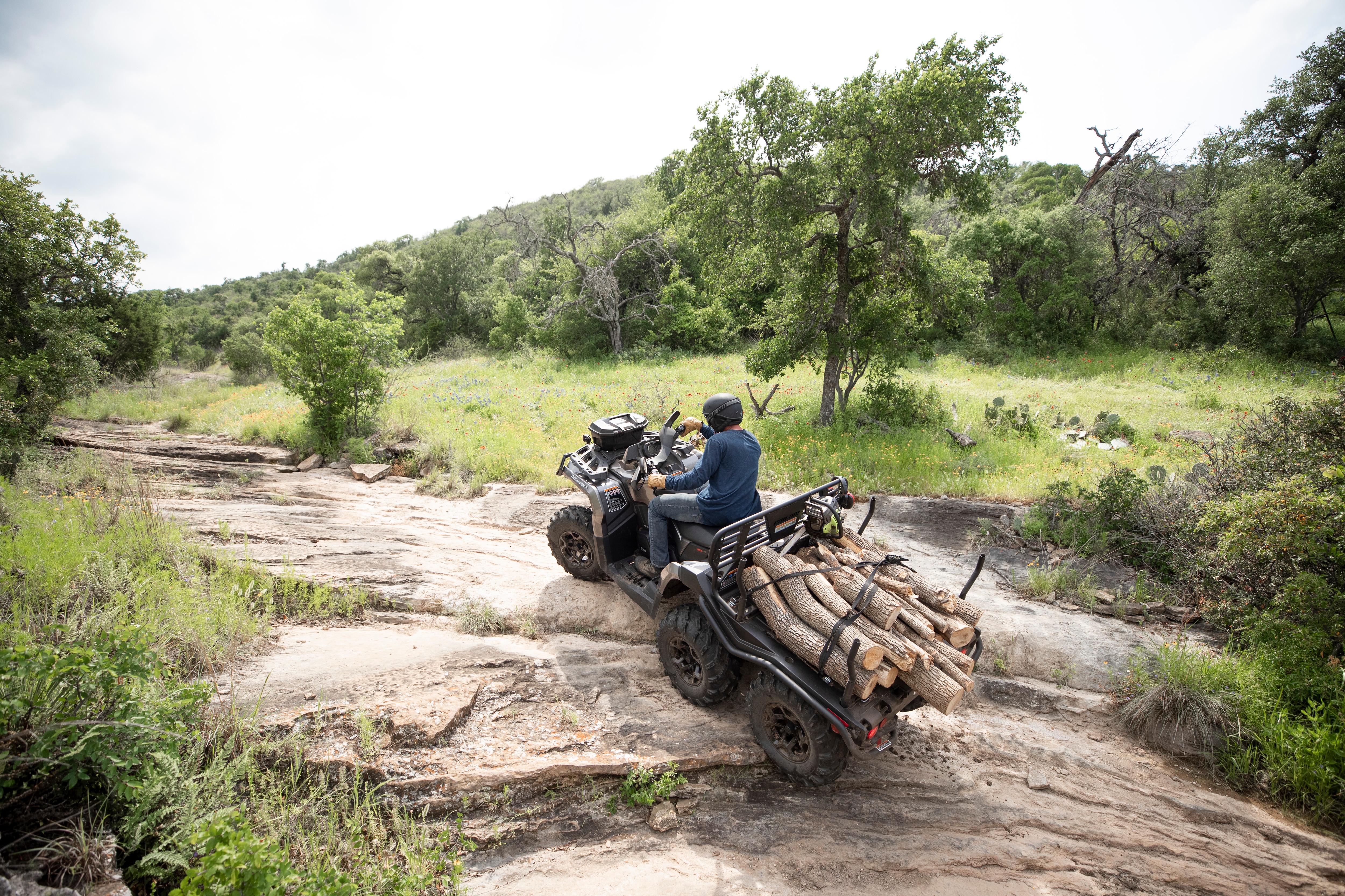 Cuatro ganaderos sentados en una cerca de ganado junto a un Can-Am Defender MAX Lonestar CAB Night Black