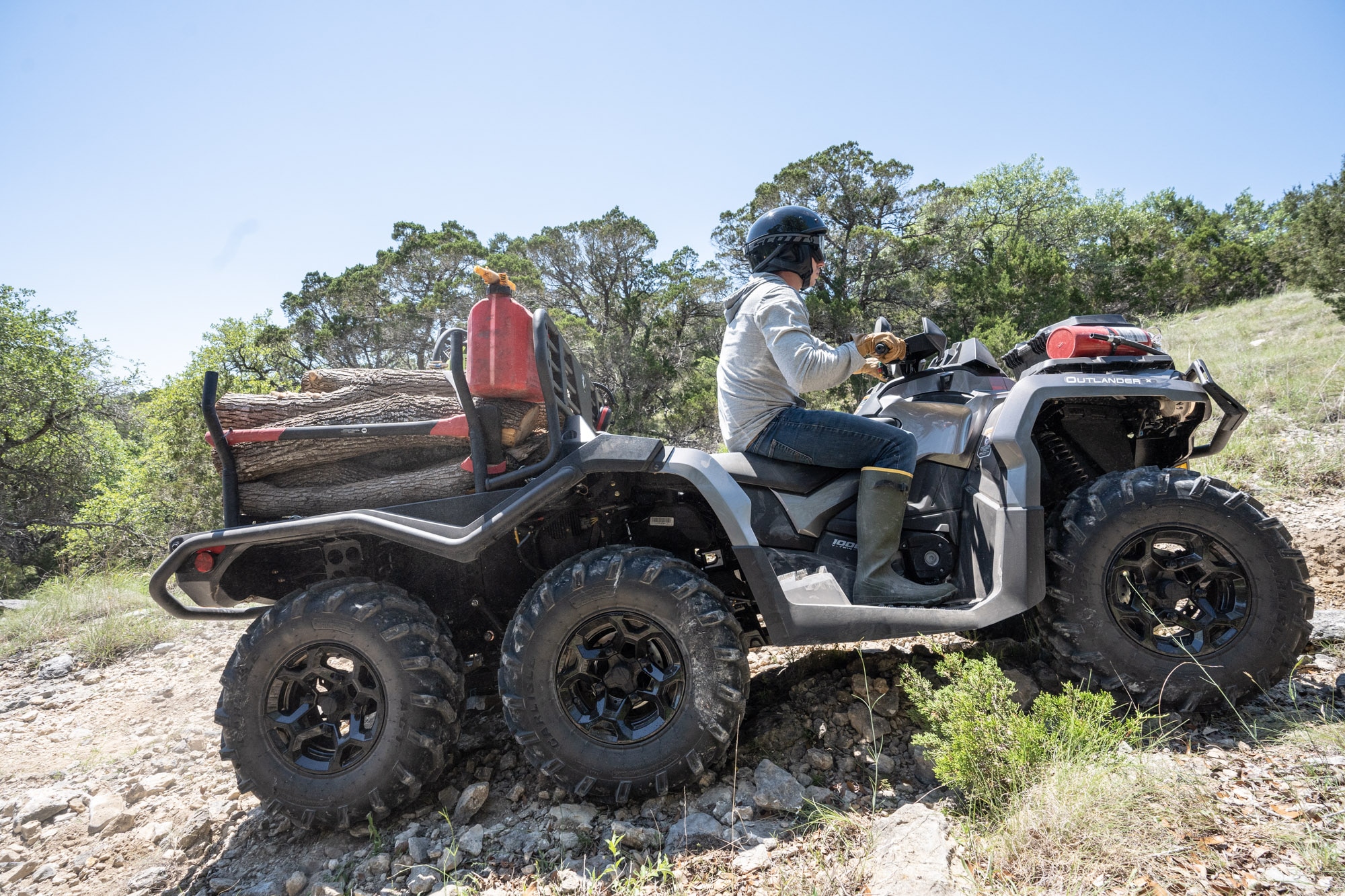 Un trabajador sosteniendo una motosierra caminando hacia su Outlander PRO XU verde tundra