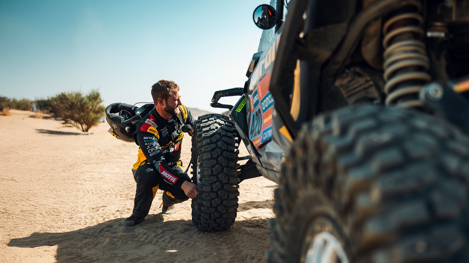 Can-Am racer fixing a front left tire