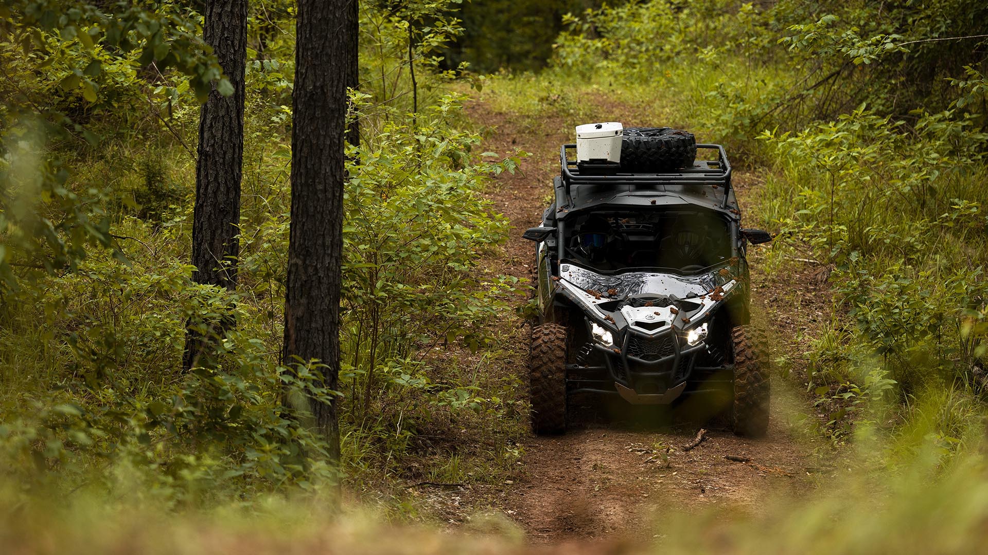 Un vehículo Can-Am SxS circulando por un sendero forestal