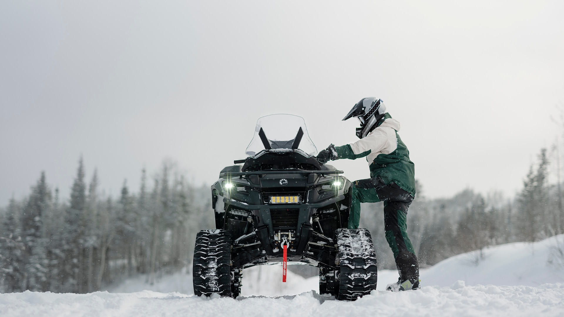 ATV Outlander with a track system idle on a snowy field