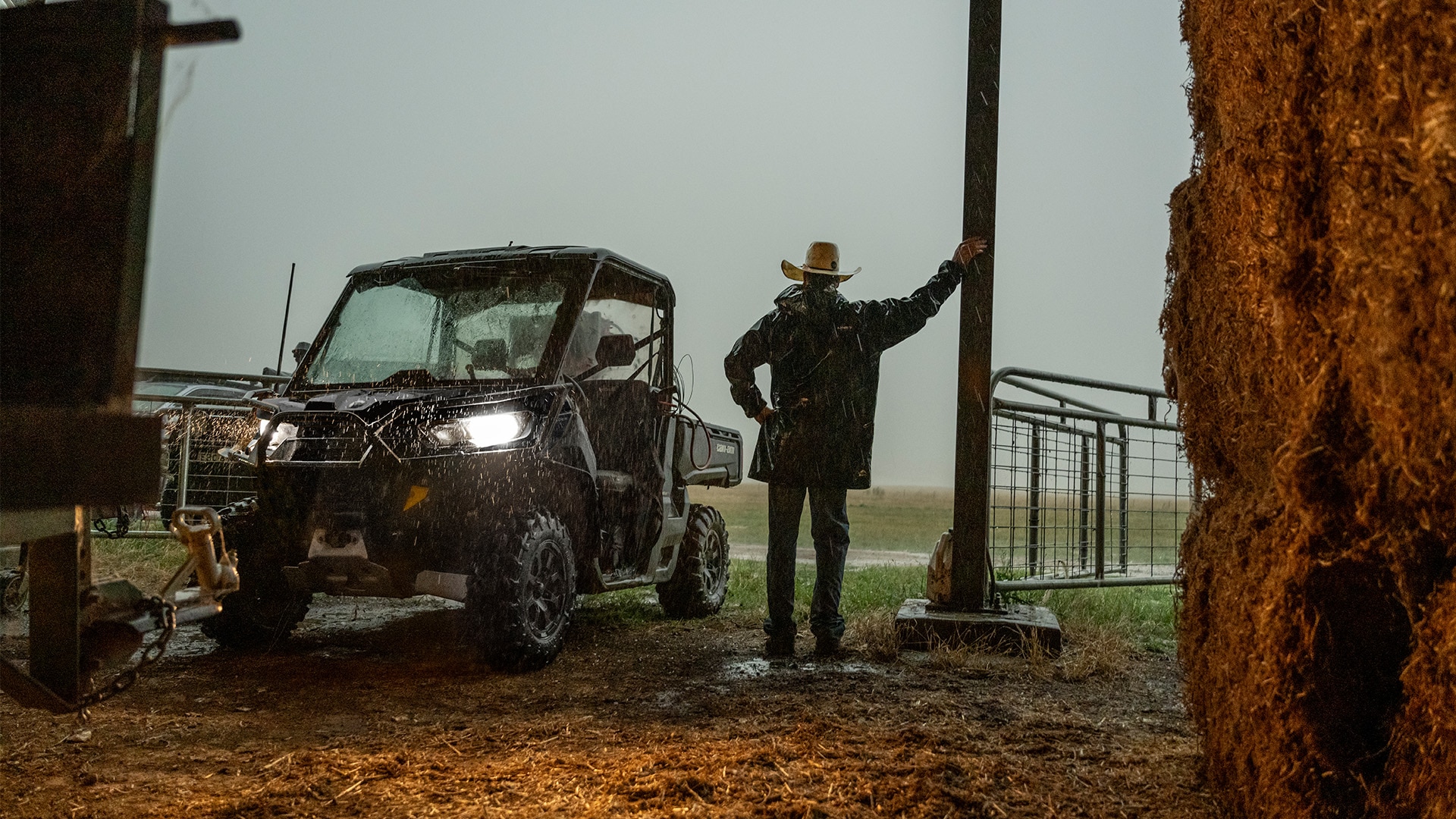 Un agricultor trabajando bajo la lluvia con su vehículo side-by-side Can-Am Defender DPS HD9