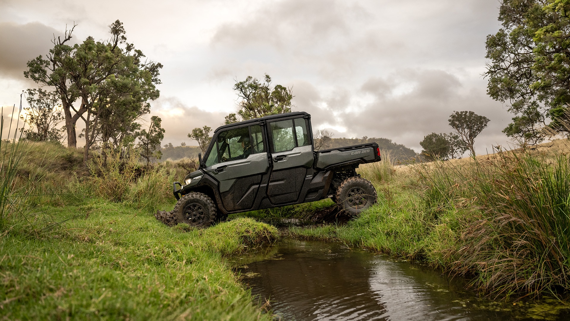 Un Can-Am Defender MAX LTD HD10 cruzando un arroyo en su granja