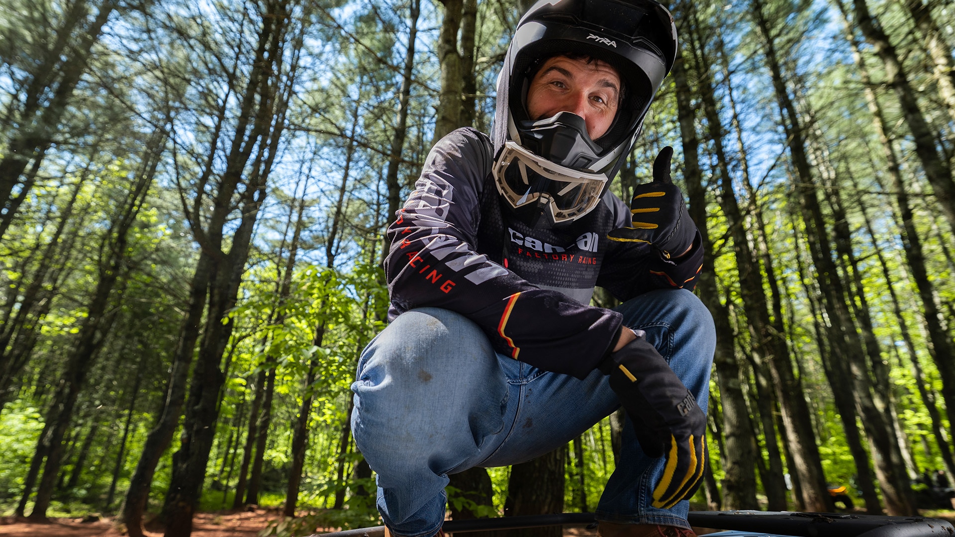 Conductor con equipo de Can-Am de pie sobre un Outlander ATV
