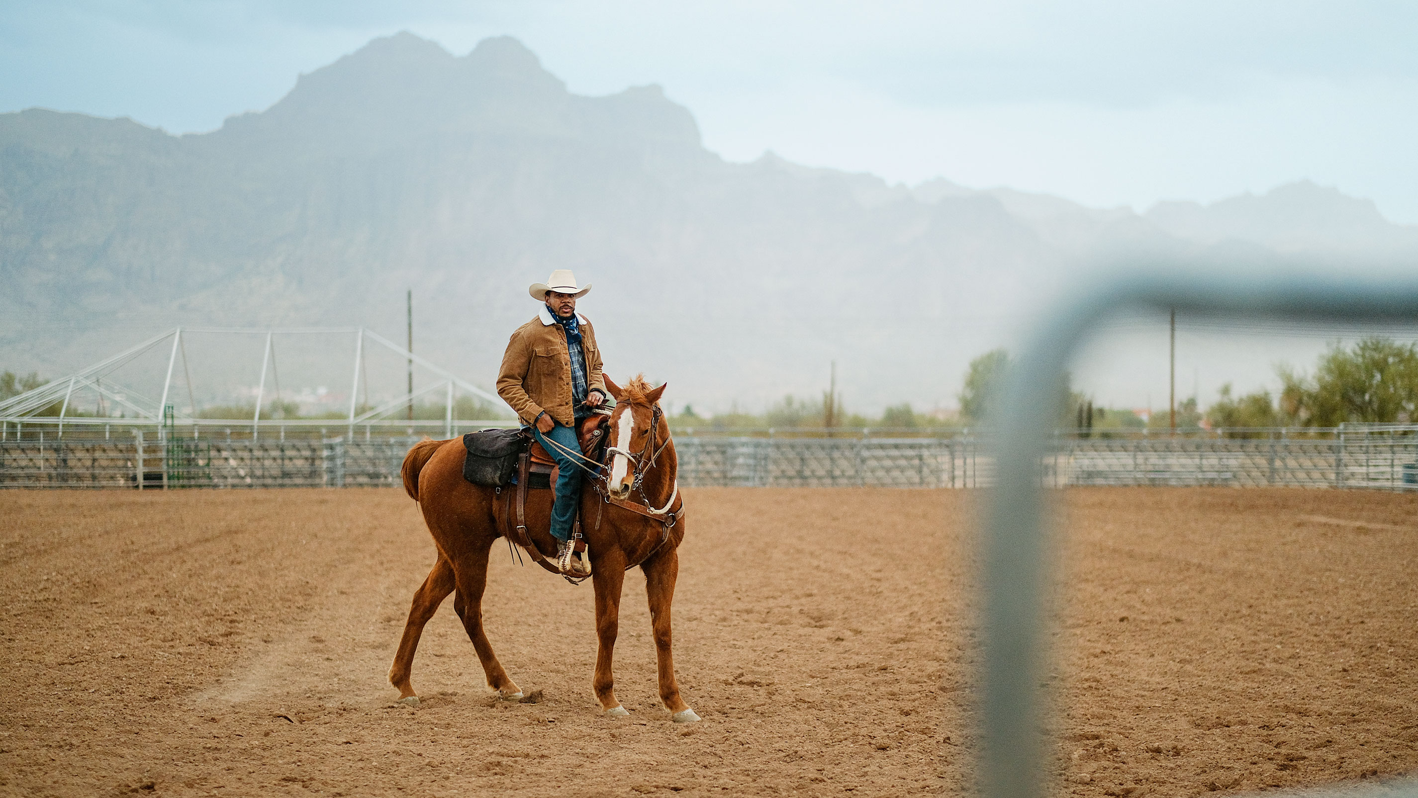 Um homem montado em um cavalo em uma arena.