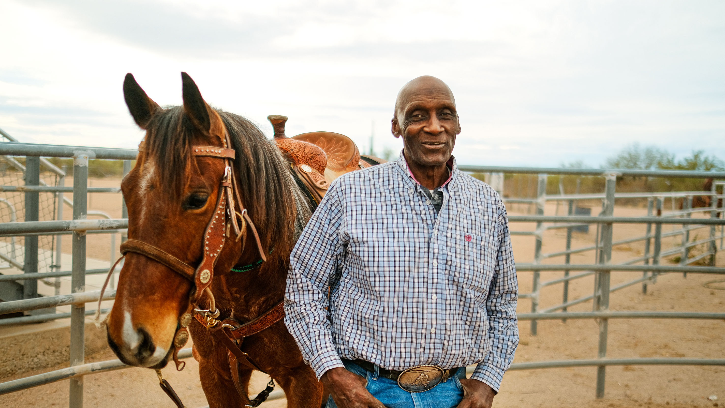 Um homem em pé ao lado de seu cavalo