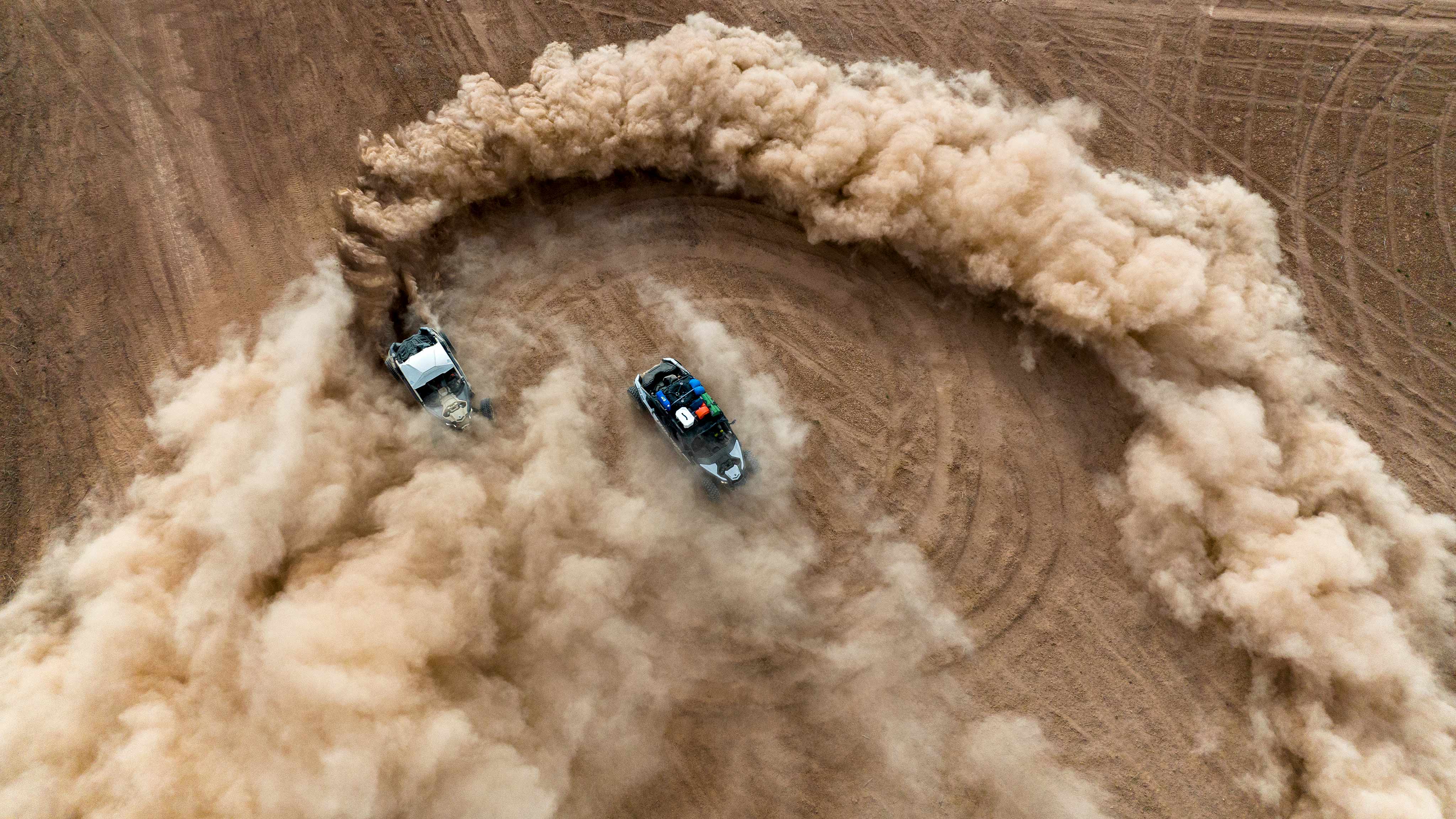 Arial view of a Mineral Grey and Desert Tan Can-Am Maverick X3 RC 72 Turbo RR and a Catalyst Grey Maverick X3 MAX DS Turbo in a desert setting